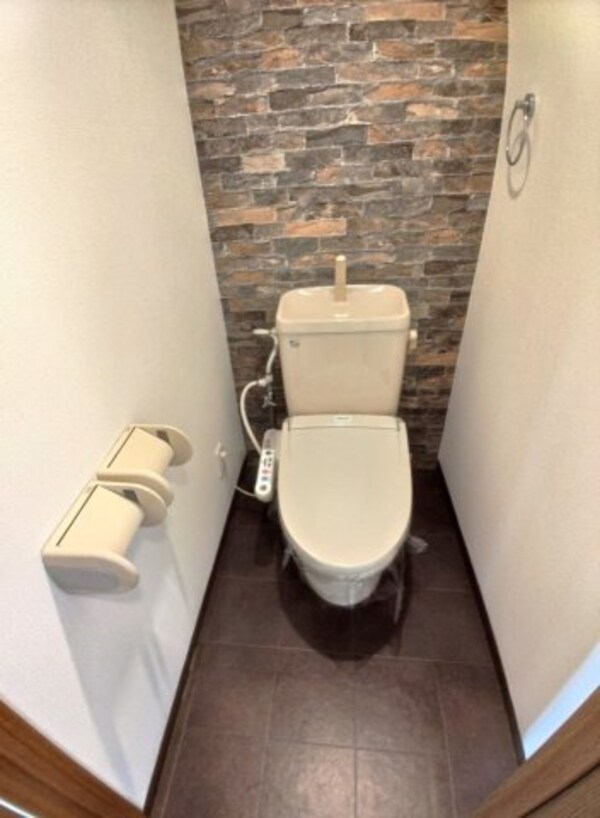 トイレ(レンガ風のアクセントクロスを使った落ち着きあるトイレ空間です)