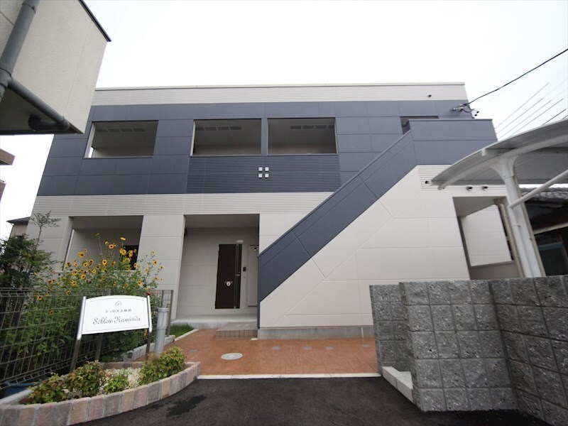 物件外観写真1　(外観　屋根付き駐輪場有り　敷地内平面駐車場)